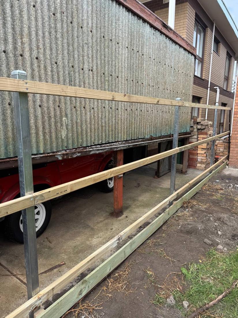 Galvanised steel-post fence framing on an exposed bayside block near St Leonards